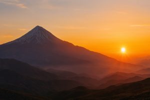 طلوع دماوند با نور طلایی سحرگاهی، ابرهای نرم و چشم‌انداز وسیع البرز در قاب سینمایی