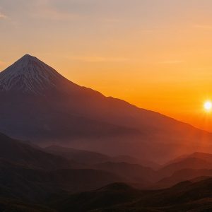طلوع دماوند با نور طلایی سحرگاهی، ابرهای نرم و چشم‌انداز وسیع البرز در قاب سینمایی