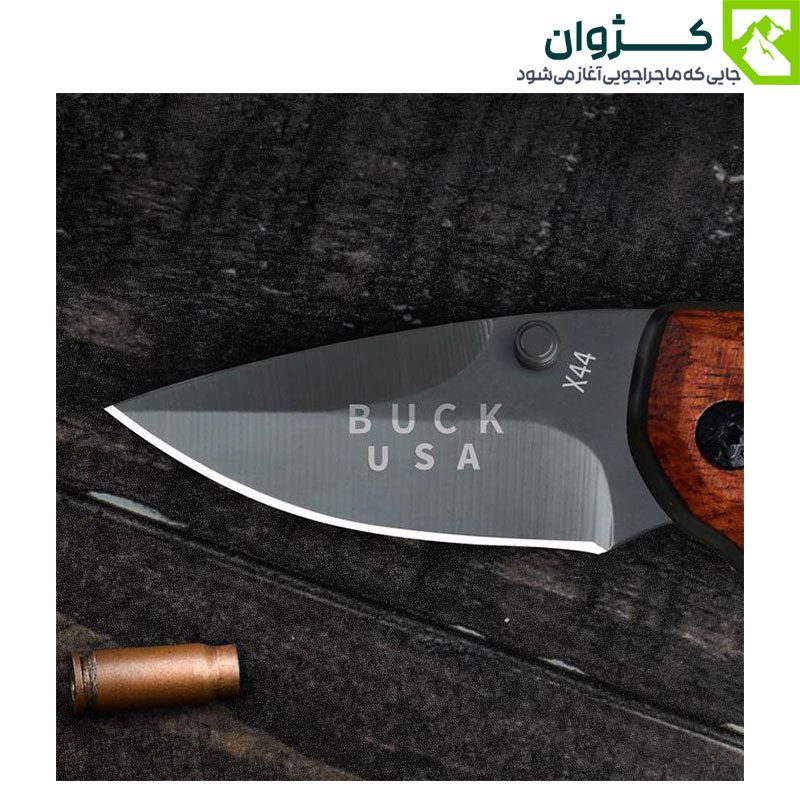 تیغه چاقوی باک X44 روی میز سیاه در کنار پوکه فشنگ، با نورپردازی مینیمال و فضای رویایی.