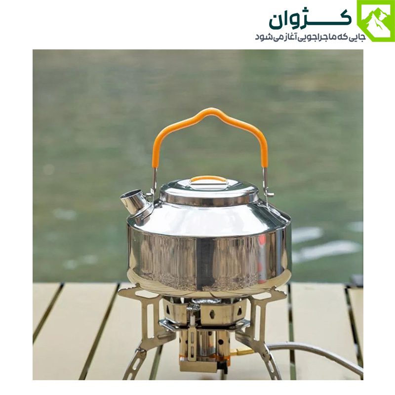 کتری استیل 0.9 لیتری روی اجاق کمپینگ در کنار رودخانه، آماده‌ی جوشاندن آب در فضای باز.