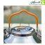 نمای نزدیک از نیمه بالای کتری استیل 0.9 لیتری با نمایش دستگیره سیلیکونی و درب استیل، در پس‌زمینه‌ای از طبیعت سبز.