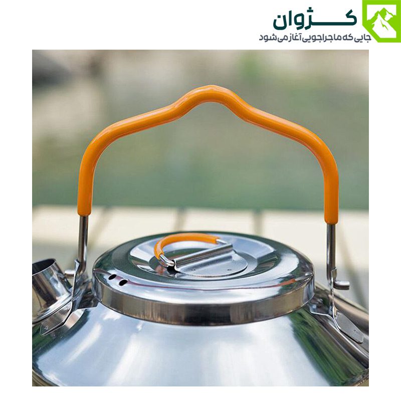 نمای نزدیک از نیمه بالای کتری استیل 0.9 لیتری با نمایش دستگیره سیلیکونی و درب استیل، در پس‌زمینه‌ای از طبیعت سبز.