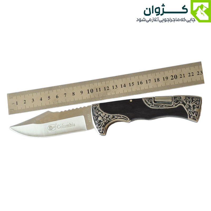 چاقوی کلمبیا مدل A3157-1 در حالت باز، کنار خط‌کش میلی‌متری قرار گرفته تا طول دقیق تیغه (۱۰.۵ سانتی‌متر) و دسته (۱۲.۵ سانتی‌متر) به‌وضوح قابل مشاهده باشد.