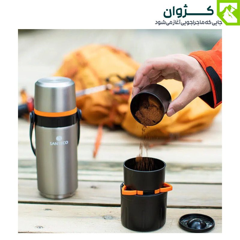 ریختن پودر قهوه از ظرف مخصوص فلاسک سانتکو داخل فیلتر دم‌آوری، نمای نزدیک از دست و میز چوبی