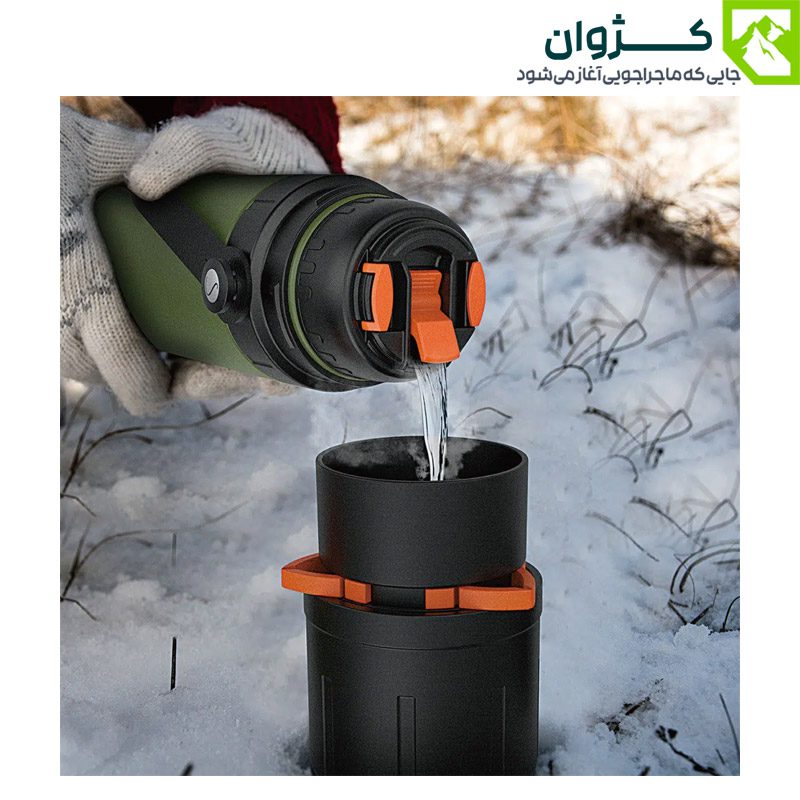 فلاسک سبز در دست طبیعت‌گرد در فضای برفی در حال دم‌آوری قهوه