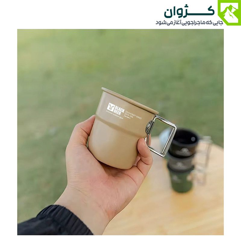 لیوان بلک‌دیر – رنگ خاکی، روی میز کمپینگ با تجهیزات سفر، نمایش کاربردی بودن محصول