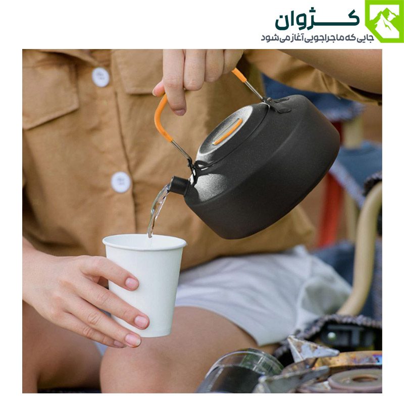 ریختن آب جوش از کتری کمپینگ BLACK DEER مدل K02 رنگ مشکی در لیوان کاغذی در فضای طبیعت‌گردی