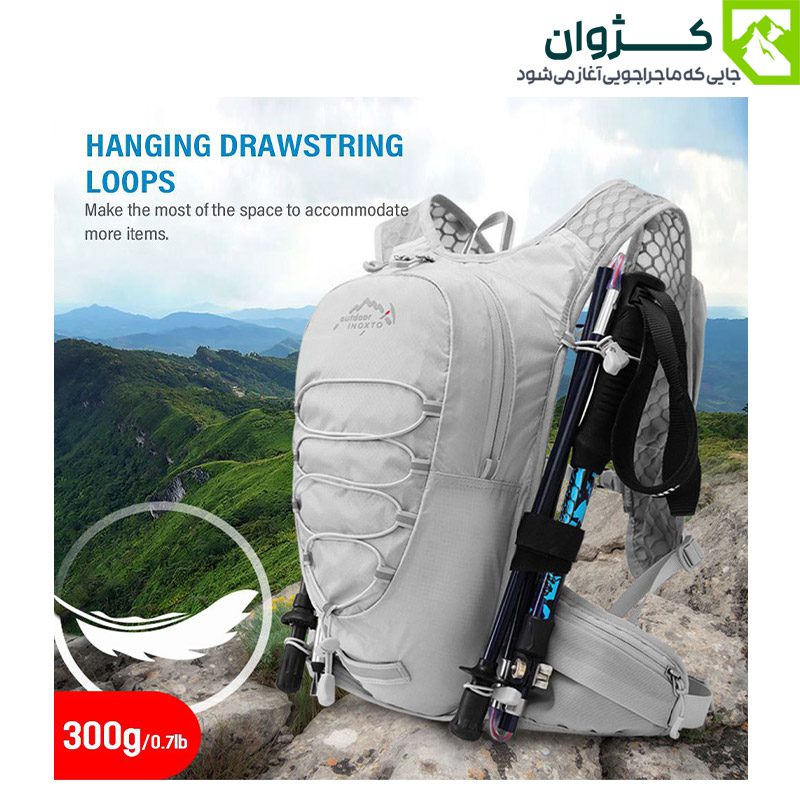 کوله رانینگ INOXTO مدل 577 در رنگ خاکستری روشن، قرار گرفته روی سطح سنگی با پس‌زمینه کوهستانی، دارای بند نگه‌دارنده تجهیزات و طراحی سبک، مناسب برای طبیعت‌گردی و دوچرخه‌سواری