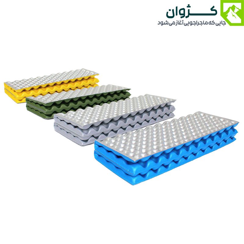 چهار زیرانداز آکاردئونی با سطح نقره‌ای و رنگ‌های زرد، سبز، خاکستری و آبی؛ چیده شده به‌صورت پلکانی در فضای باز، مناسب برای کمپینگ و طبیعت‌گردی